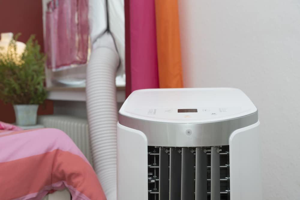A cooling appliance in the bedroom with an exhaust hose running through the window
