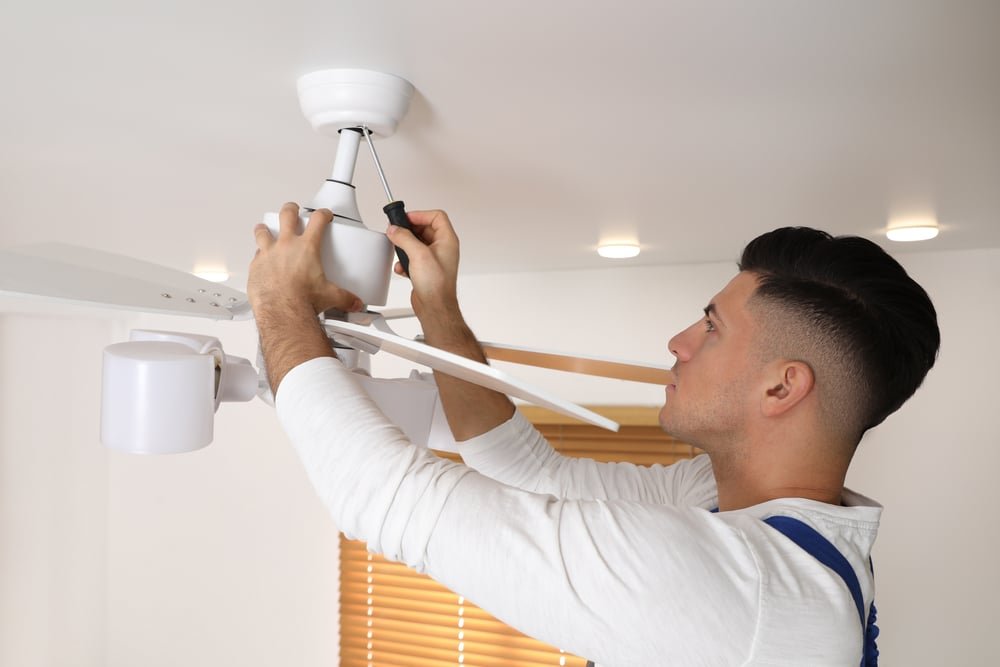 A man installs an appliance indoors.