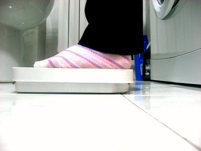 A woman stands on a weighing device