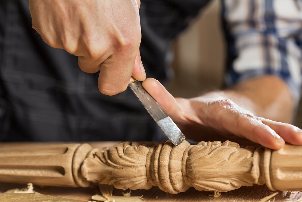 Close up of carpenter's hands working with cutter in his studio