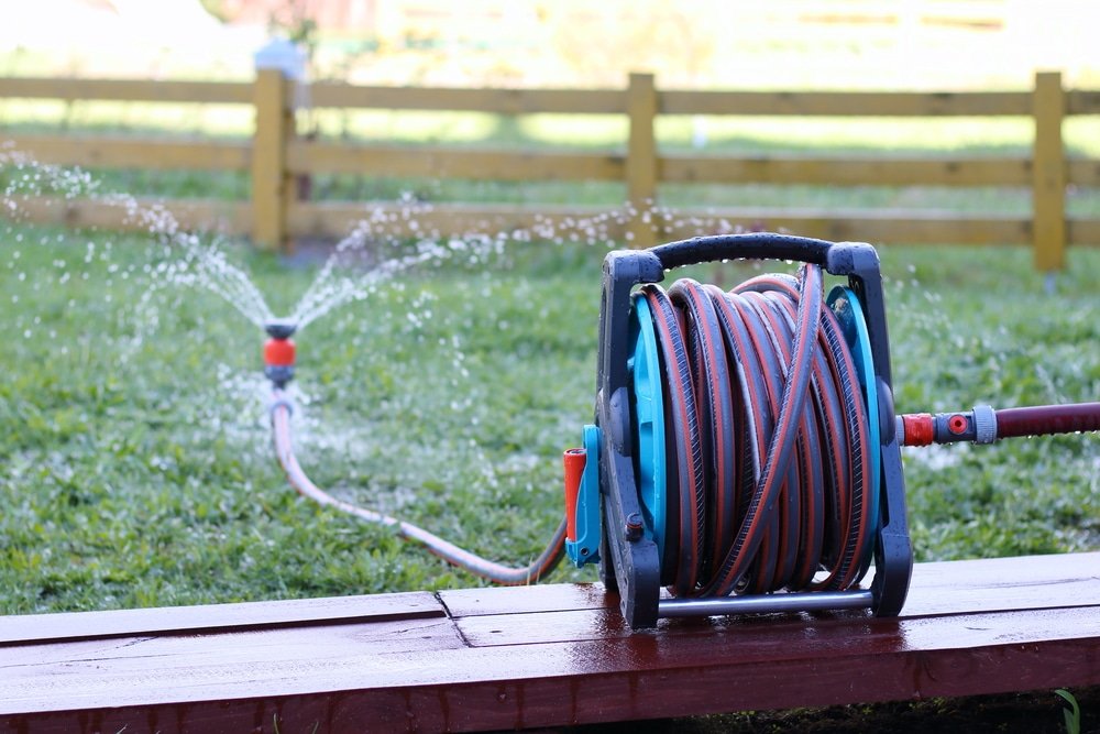 Water is being sprayed in the backyard