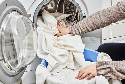 a woman loading laundry into the device